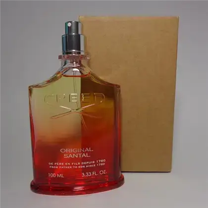 Uncapped Creed Original Santal bottle placed beside plain brown tester box on flat surface