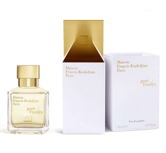 Fragrance tester Gentle Fluidity Gold placed beside white and gold branded box, elegant arrangement